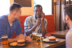 Man telling his friends to be quiet while on the phone in the pub